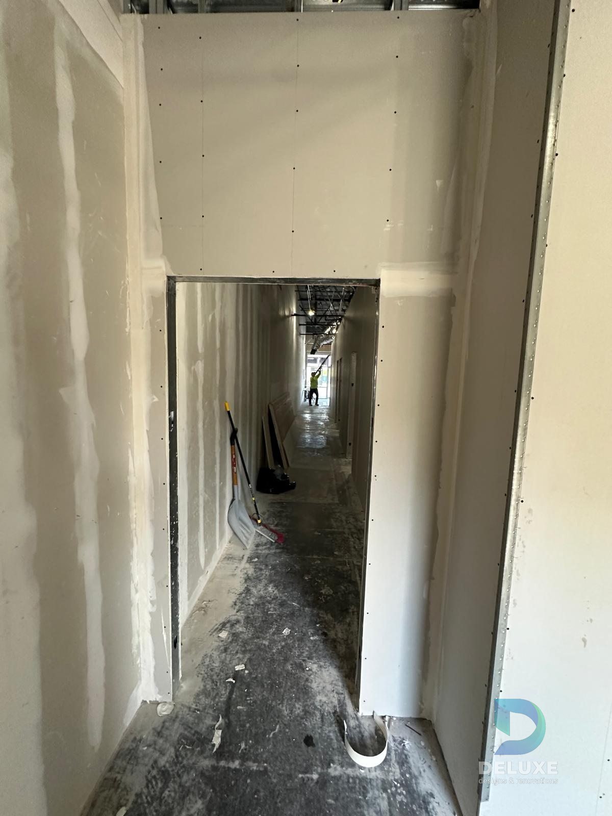 Milan Laser Valrico commercial buildout project with Deluxe Designs & Renovations watermark - Milan Laser Valrico Corridor Drywall Finish