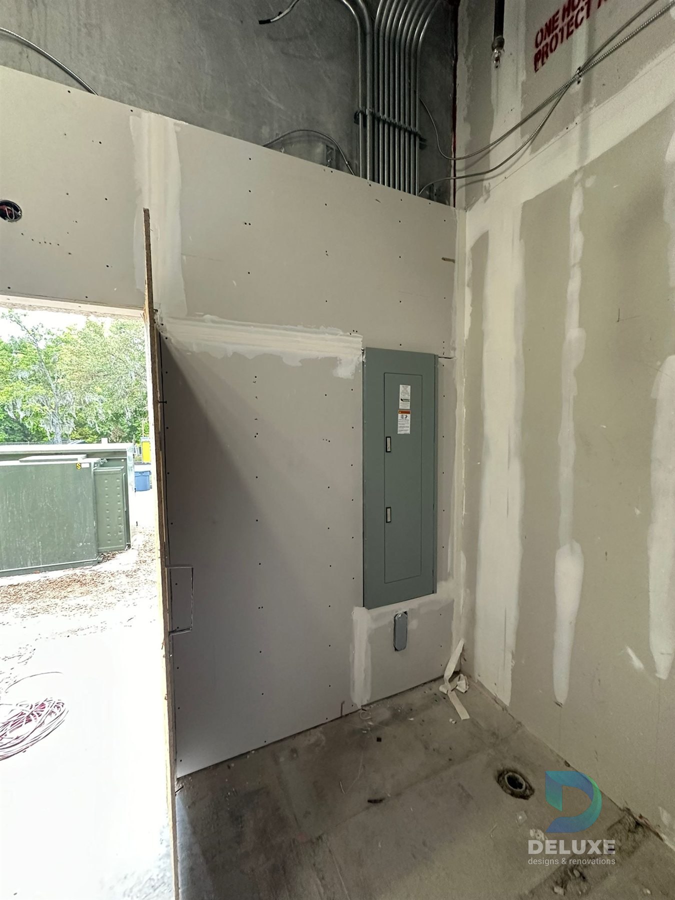Milan Laser Valrico commercial buildout project with Deluxe Designs & Renovations watermark - Milan Laser Valrico Electrical Panel Area