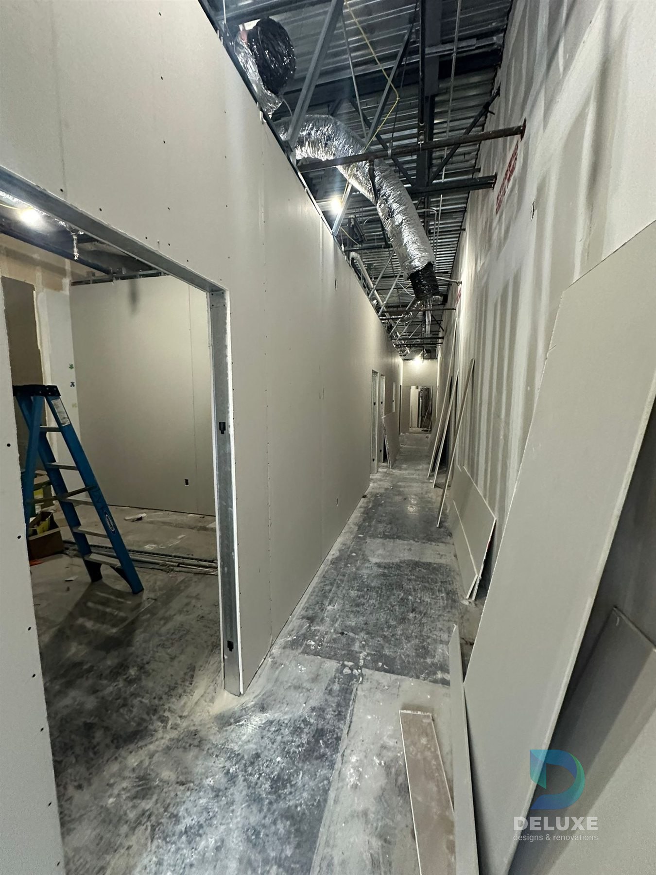 Milan Laser Valrico commercial buildout project with Deluxe Designs & Renovations watermark - Milan Laser Valrico Hallway Drywall Progress
